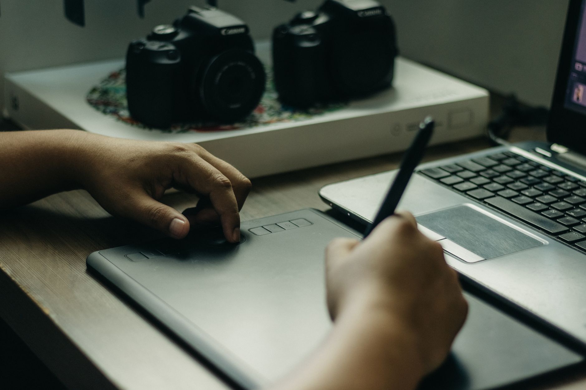 Graphic designer using a pen tablet and stylus to edit images on a computer