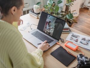 Person editing a photo on a laptop using creative software at a desk