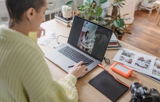 Person editing a photo on a laptop using creative software at a desk