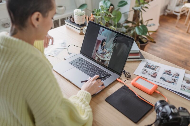 Person editing a photo on a laptop using creative software at a desk