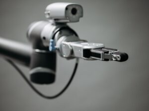 Robotic arm reaching into an open toolbox of hand tools on a workbench