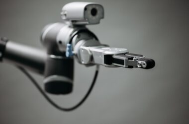 Robotic arm reaching into an open toolbox of hand tools on a workbench