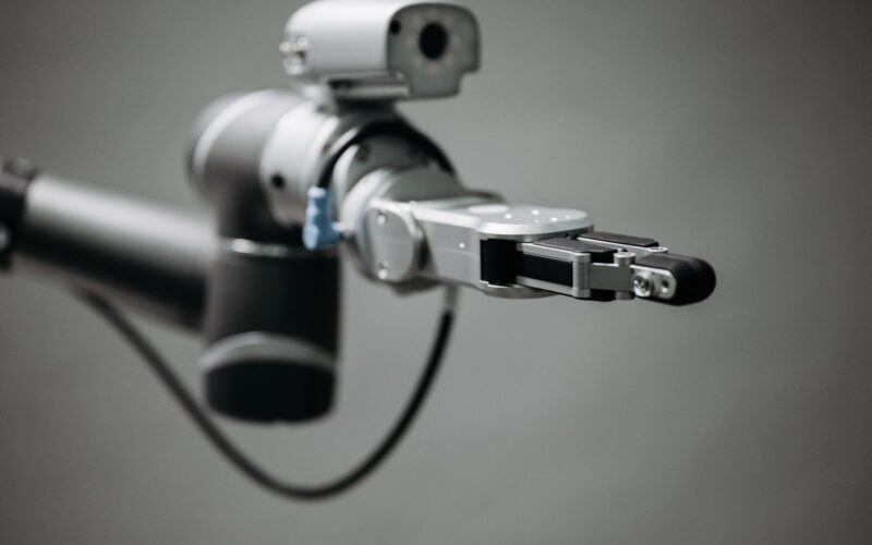 Robotic arm reaching into an open toolbox of hand tools on a workbench