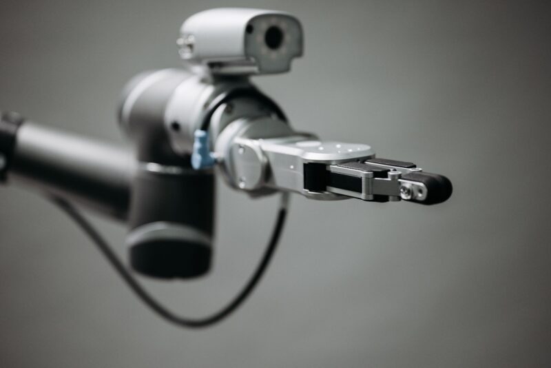 Robotic arm reaching into an open toolbox of hand tools on a workbench